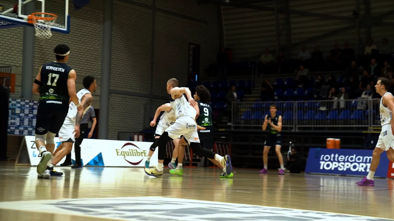 Spelers onder de basket tijdens een wedstrijd in het Topsportcentrum Rotterdam
