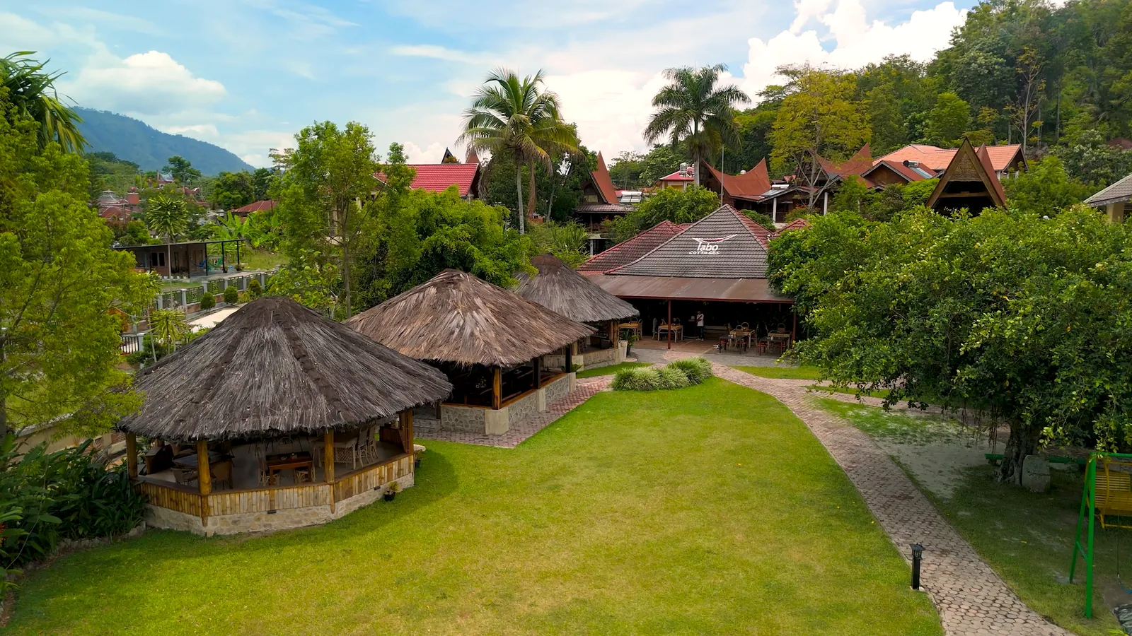 Dronebeeld van een resort met zwembad en tuinen