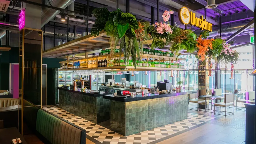 Bar van Seoul Sista met hangende planten, neonverlichting en een tegelwand