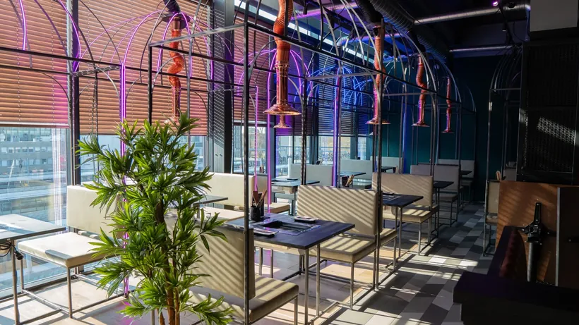 Lichte eetzaal van Seoul Sista met hoge ramen, tafels en planten