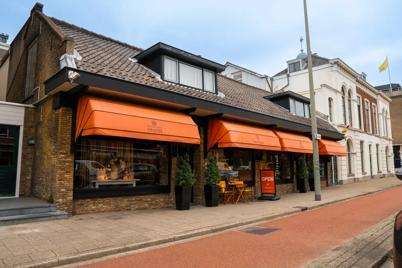 Winkelpand van Wijnhuis Oranje met oranje zonneschermen, van buiten gefotografeerd