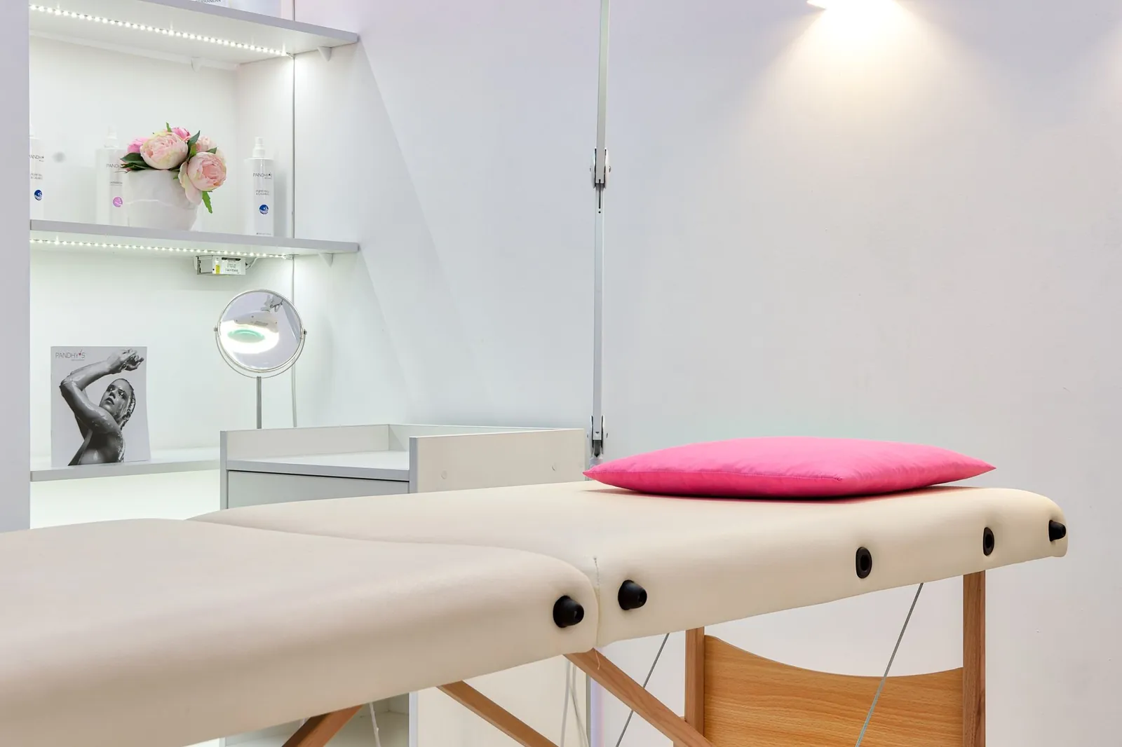 Behandeltafel met een roze kussen in een witte salon