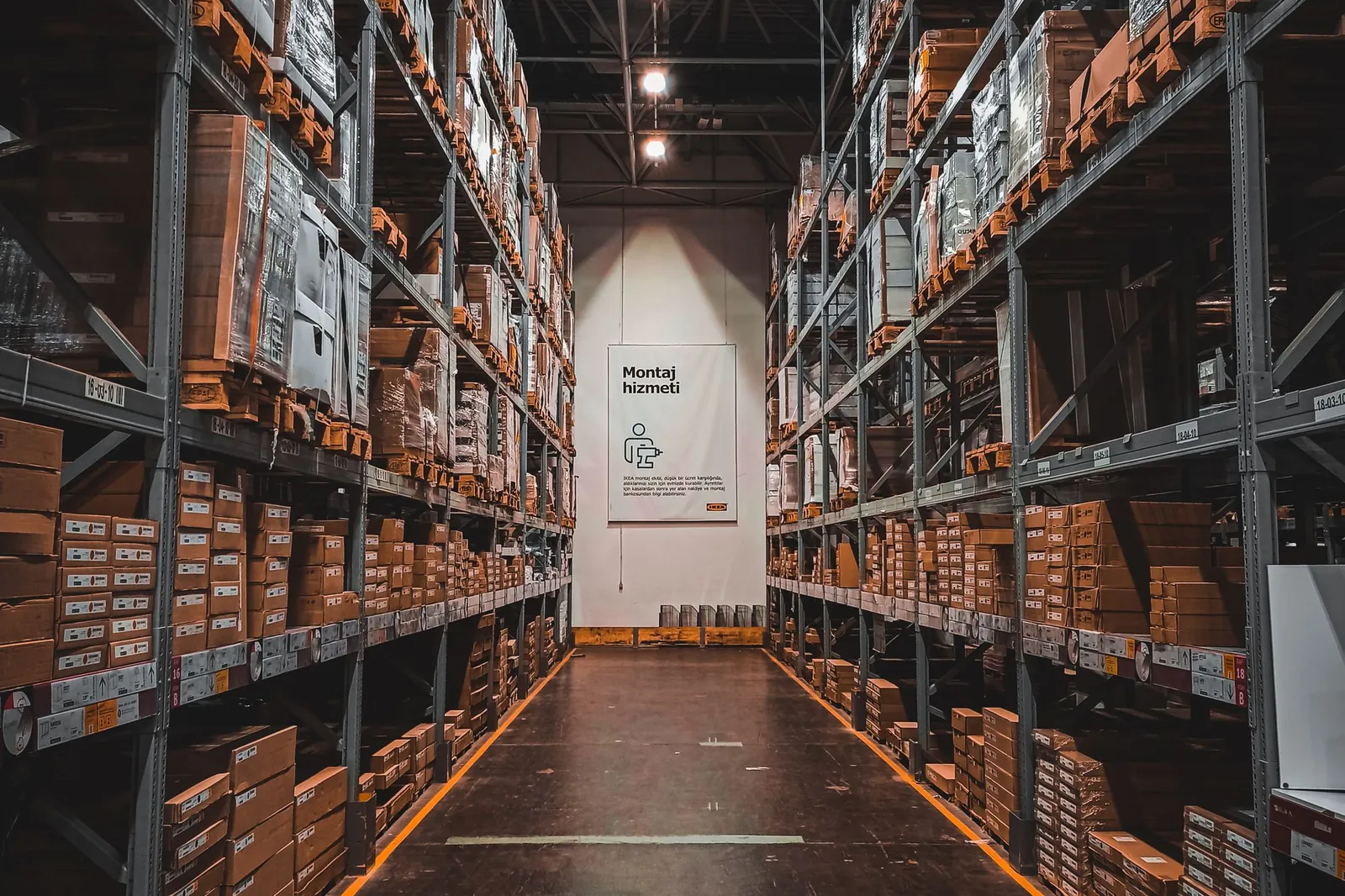 Magazijngang met stellingen vol kartonnen dozen