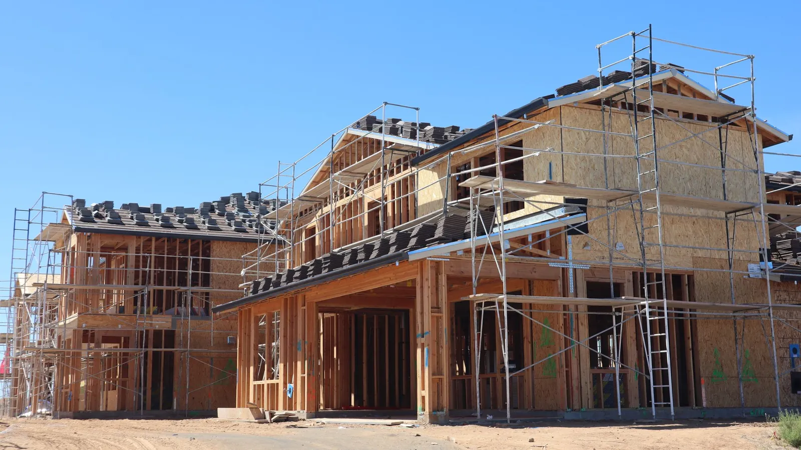 Nieuwbouwwoning in aanbouw met houten skelet en steigers