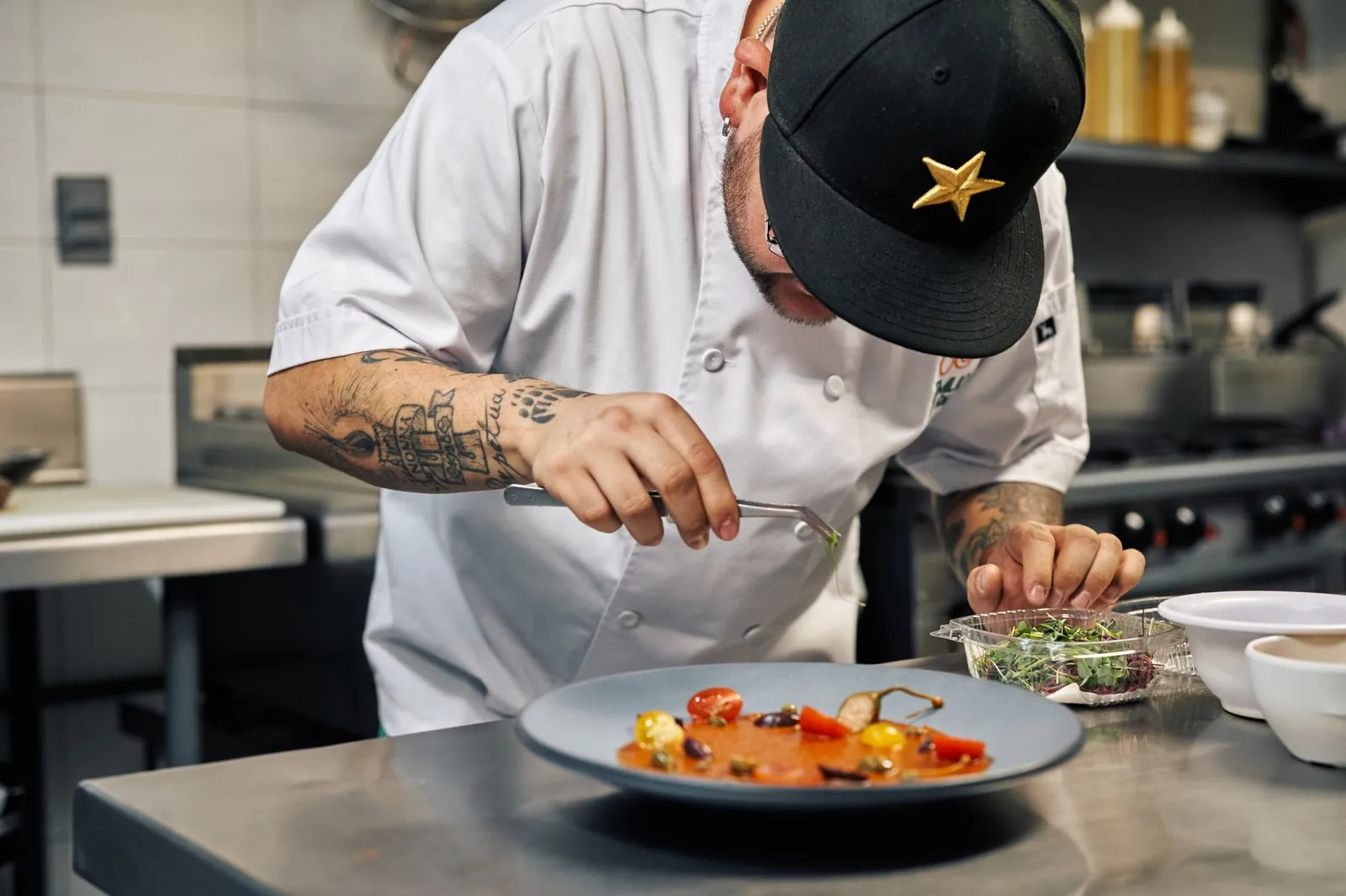 Kok werkt een bord met een gerecht af in een professionele keuken