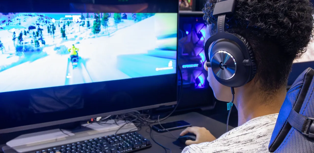 Gamer met koptelefoon achter een pc, de openingsfoto van Overklokt